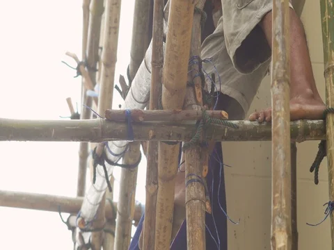 Worker climbing on bamboo scaffold with barefoot Stock Footage 74071254