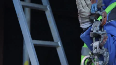 The worker climbs a ladder with a chain in his hand Stock Footage 137577299