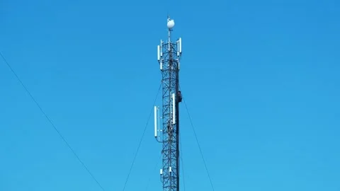 Worker climbs up a mobile phone tower. Two workmen on cell tower Stock Footage 311833069