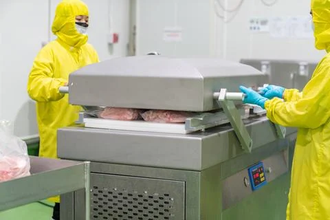 Worker close cover vacuum machine for vacuum raw chicken seal bag. Stock Photos