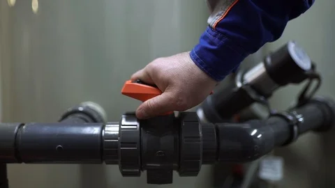 The worker closes the valve on the pipe and stops the water supply to the tank Stock Footage 92590027