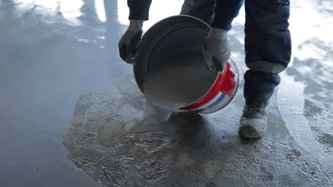 Worker, coating floor with self-leveling epoxy resin in the workshop of the p Stock Footage 150877043