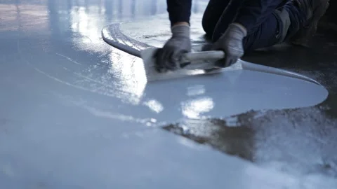 Worker, coating floor with self-leveling epoxy resin in the workshop of the p Stock Footage 150877095