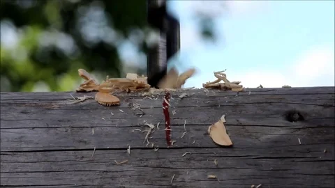 The worker collects the frame and drills a hole in a log for dowel using a drill Stock Footage 77427248