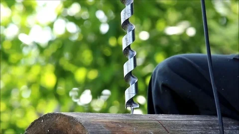 The worker collects the frame and drills a hole in a log for dowel using a drill Stock Footage 77427360