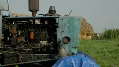 Worker collects hay - on the fore plan tractor Stock Footage 121491597