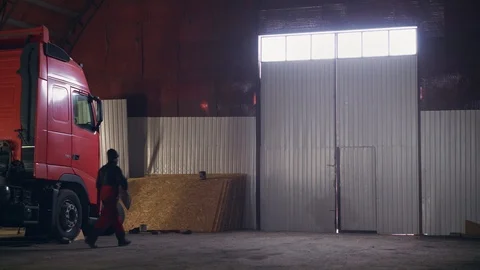 Worker comes out of a large hangar with a truck Stock Footage 104222811