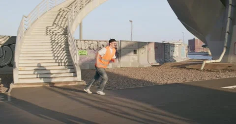 Worker comically runs and unexpectedly stumbles on a skateboard Stock Footage 244613987