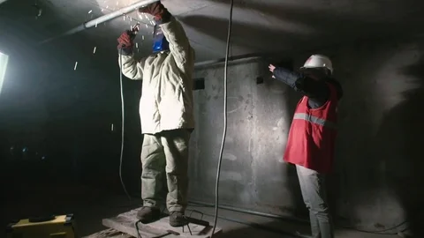 Worker communicates with the welder Stock Footage 82301055