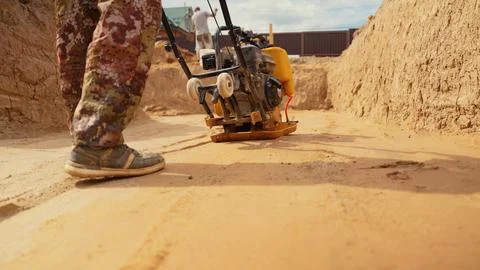 Worker compacting sand for a strong foundation base Stock Photos