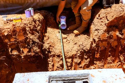 Worker completes plumbing task in construction site d Stock Photos