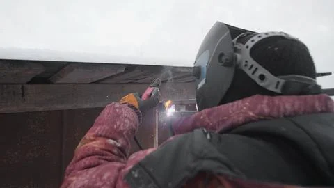 Worker Conducts Welding Activity in Cold Outdoor Environment During Winter Foto stock
