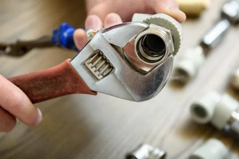 A worker is connecting elements of the plumbing. Stock Photos