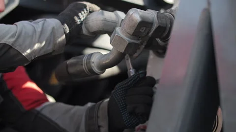 Worker connecting hydraulic hoses on heavy transport equipment Stock Footage 345080987
