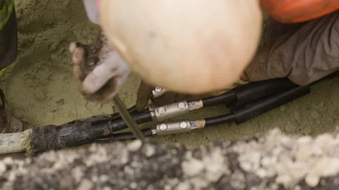 The worker is connecting two power transmission line cables and tightening the Stock Footage 244644040