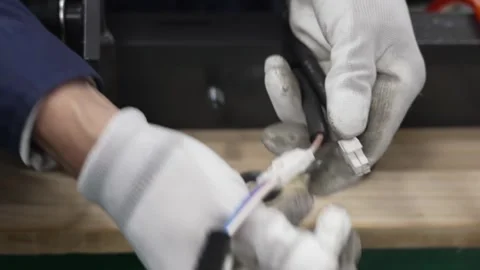 Worker connecting wire harness cable with multi-pin connector using crimping Stock Footage 334964845
