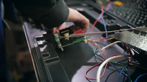 A worker connects the chips of a traffic light at a production site. Close-up Stock-Footage 137579155