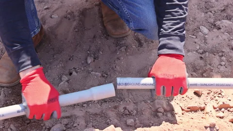 Worker connects PVC pipes in construction site using gloves tools Stock Footage 321769185