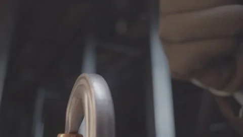 Worker connects spring snap to metal loop in semi-dark room Stock Footage 267824285