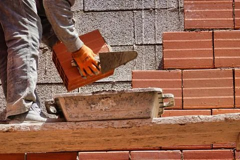 Worker constructing a brick wall in an industrial area 스톡 사진