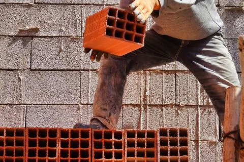 Worker constructing a brick wall in an industrial area 스톡 사진