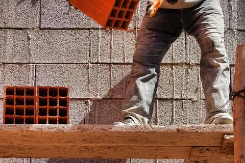 Worker constructing a brick wall in an industrial area 스톡 사진