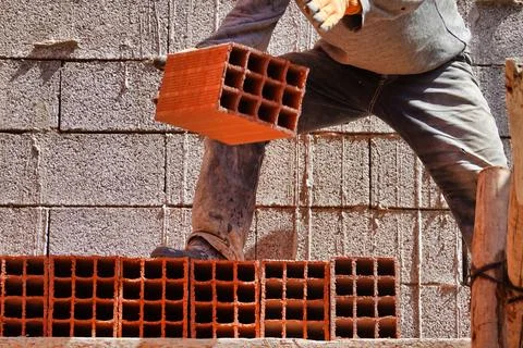 Worker constructing a brick wall in an industrial area 스톡 사진