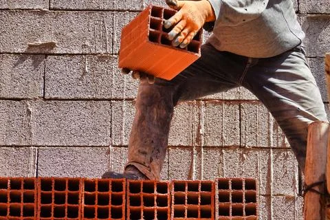 Worker constructing a brick wall in an industrial area 스톡 사진