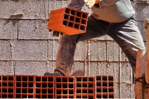 Worker constructing a brick wall in an industrial area 스톡 사진
