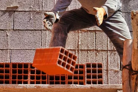 Worker constructing a brick wall in an industrial area 스톡 사진