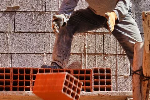 Worker constructing a brick wall in an industrial area 스톡 사진
