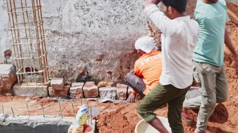 Worker constructing stone wall on basement work at construction site Stock Footage 333412922