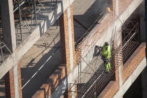 Worker at construction site is drilling a wall Stock Photos