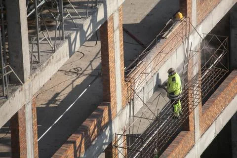 Worker at construction site is drilling a wall Stock Photos