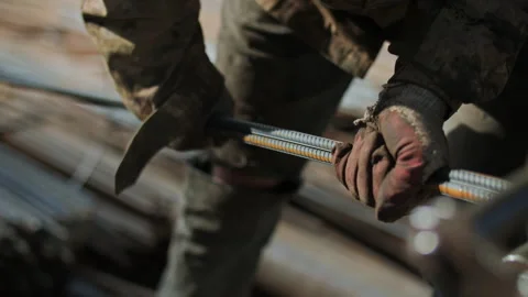 A worker at a construction site holds rebar Stock Footage 294986938