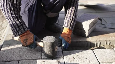 Worker at a construction site lays paving slabs Stock Footage 254511835