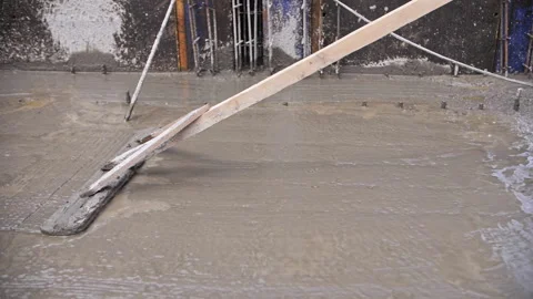 Worker at a construction site leveling poured concrete Stock Footage 241496807