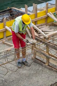 Worker at the construction site making reinforcement metal Stock Photos