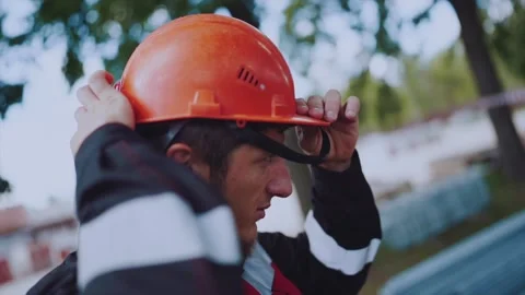 A worker at a construction site puts on a helmet Stock Footage 199323866