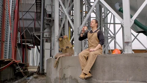 A worker on a construction site rests during a coffee break. Video stock 271629948