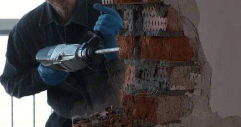 Worker at construction site splits brick wall, works with jackhammer, breaks Stock Footage 124296136