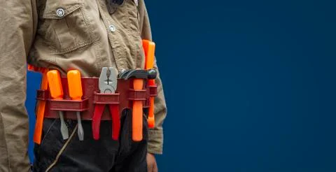 Worker with construction tools on blue background, labor day concept Stock Photos