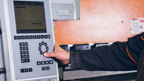 Worker controling and operating manufacturing process on a control panel. Stock Footage 77362121
