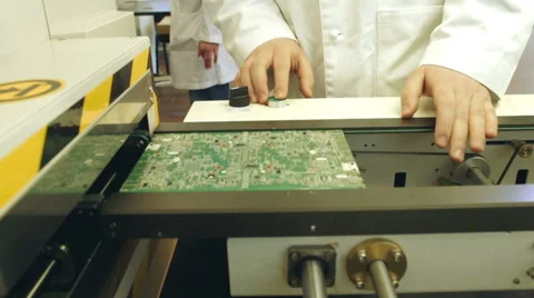 Worker controlling quality of PCB boards on production line in factory Stock Footage 50304458