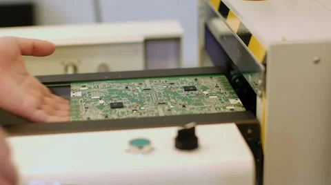 Worker controlling quality of PCB boards on production line in factory Stock Footage 50304634