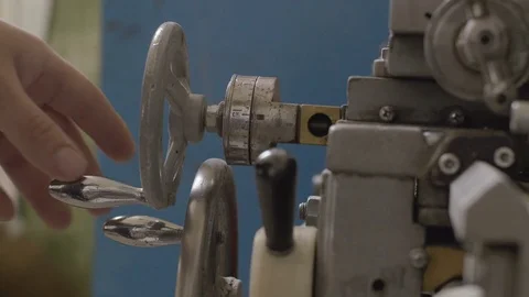 Worker controls adjustment wheel of lathe machine Stock Footage 70807288