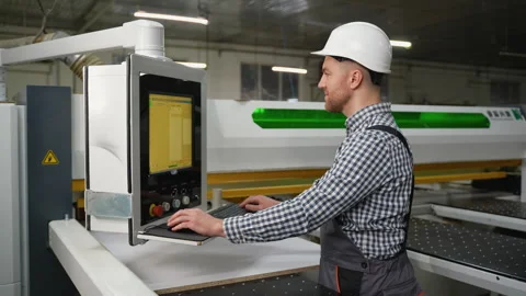 Worker Controls CNC Machine for Wood Panel Cutting Stock Footage 305600033