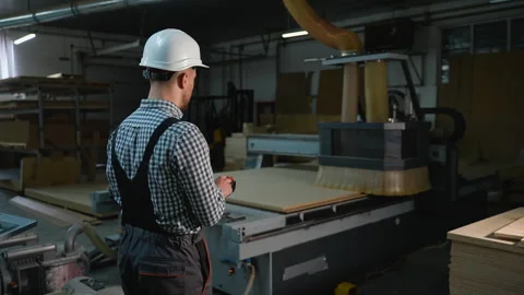Worker Controls CNC Router Cutting Wooden Panels at Furniture Factory Stock Footage 305603475