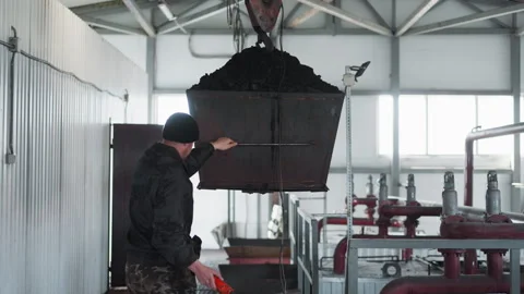 Worker controls coal bucket transportation in boiler room Video stock 243300826