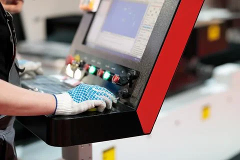 Worker at the controls of laser cutting machine Foto stock